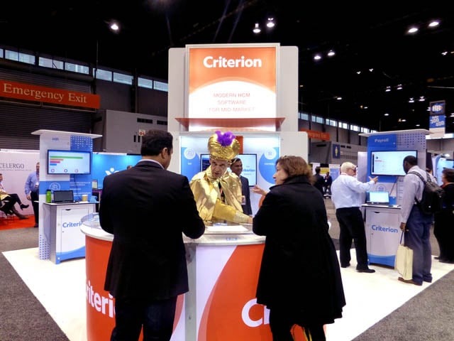 Mister Vibe analyzing the handwriting of two people at a trade show booth.