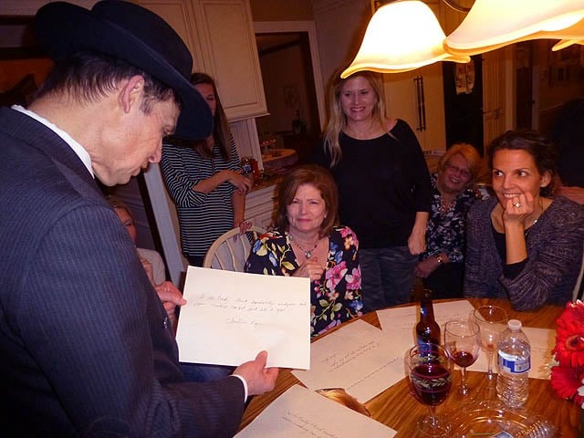 Mister Vibe analyzes the handwriting of women crowded around a kitchen table.
