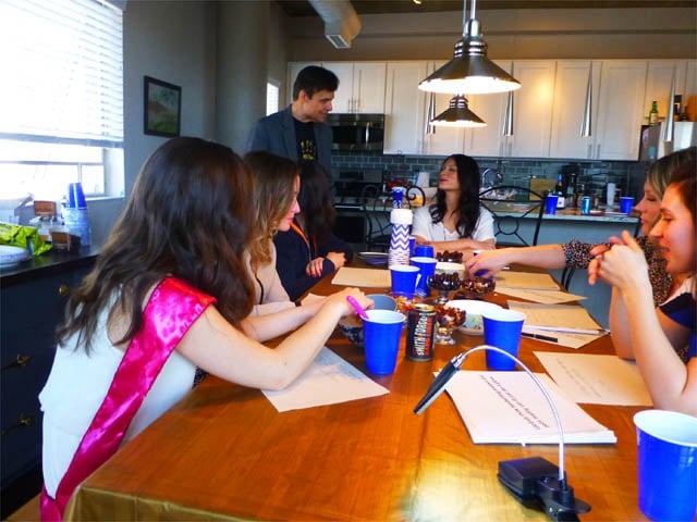 Mister Vibe analyzes the handwriting of women seated at a long kitchen table.