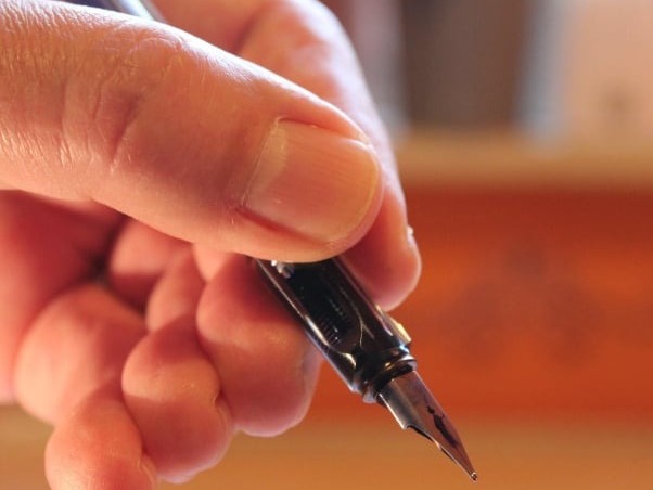Hand holding pen writing.