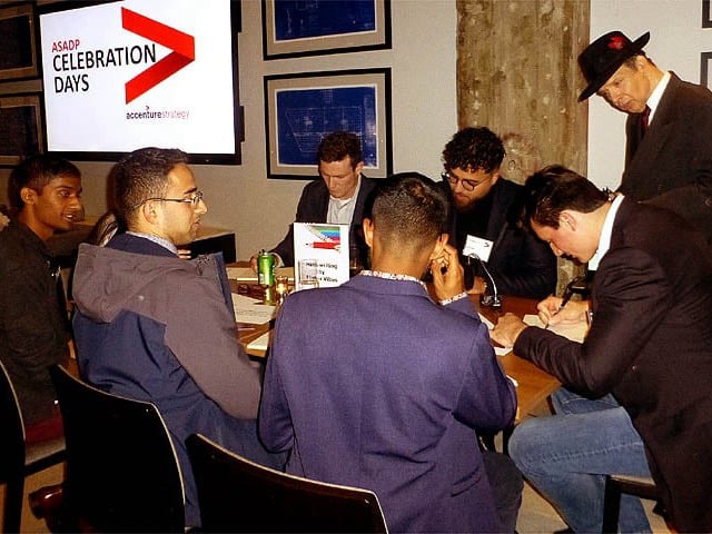 People seated at table writing handwriting samples.